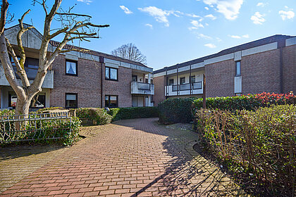 Immobilien-Eingangsbereich mit Weg durch Gartenanlage